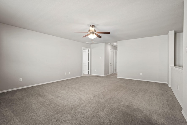 carpeted spare room featuring baseboards and a ceiling fan