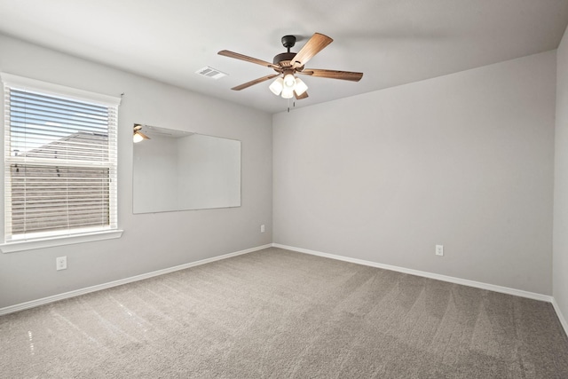 spare room featuring visible vents, carpet, ceiling fan, and baseboards