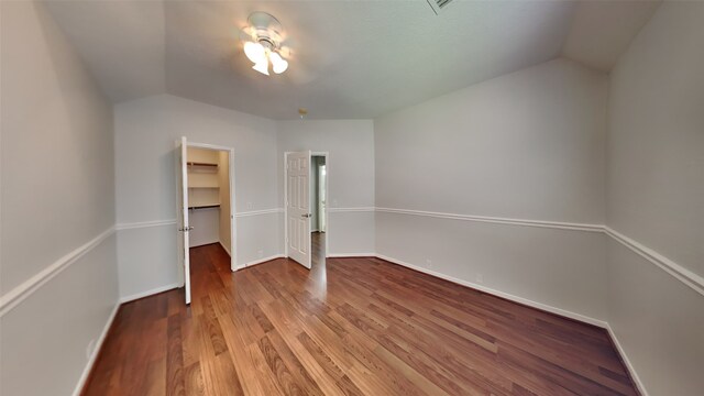 12107 Canyon Mills Dr, Houston, TX 77095 - unfurnished bedroom featuring vaulted ceiling, wood finished floors, a walk in closet, baseboards, and a closet