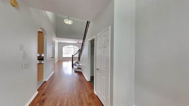 12107 Canyon Mills Dr, Houston, TX 77095 - hallway with arched walkways, light wood-type flooring, stairway, and baseboards