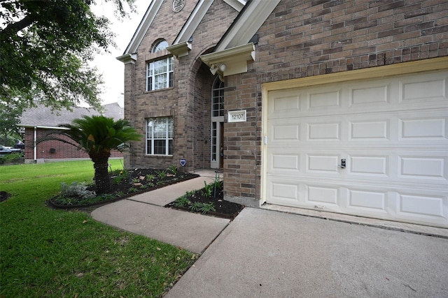 12107 Canyon Mills Dr, Houston, TX 77095 - view of exterior entry featuring a yard, driveway, and brick siding