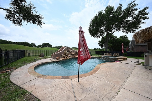 12107 Canyon Mills Dr, Houston, TX 77095 - view of pool featuring a water slide, a fenced backyard, a patio, and a pool with connected hot tub