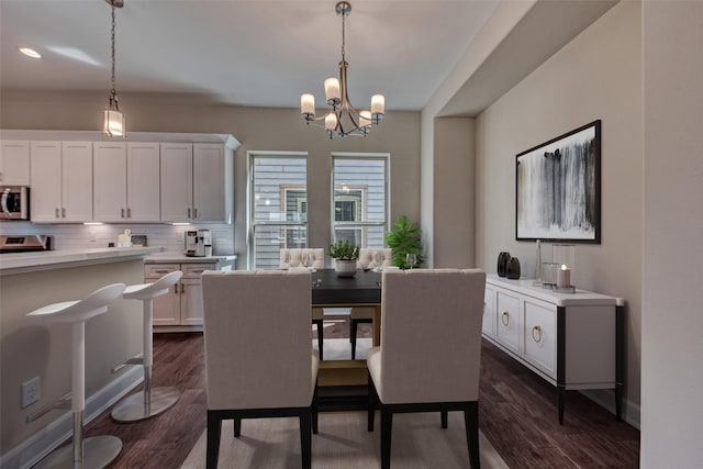 dining area featuring an inviting chandelier, recessed lighting, and dark wood-style floors