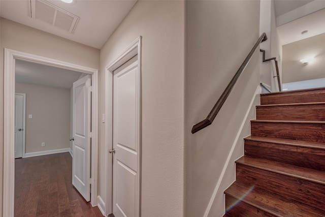 stairs with baseboards, visible vents, and wood finished floors