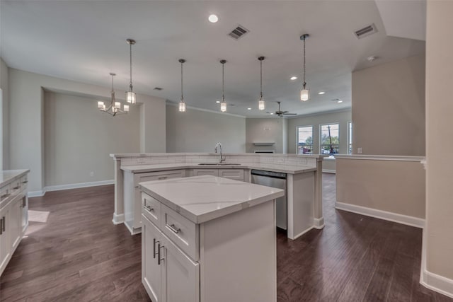 kitchen with visible vents, stainless steel dishwasher, a spacious island, a sink, and ceiling fan with notable chandelier