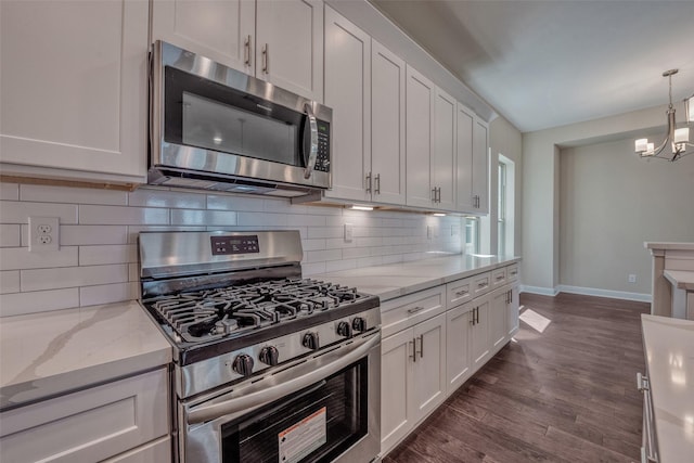 kitchen with an inviting chandelier, appliances with stainless steel finishes, tasteful backsplash, and white cabinetry