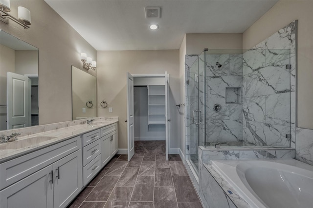 bathroom with visible vents, a marble finish shower, a sink, and a bath