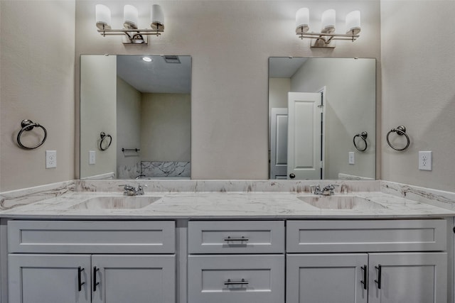 bathroom featuring visible vents, a sink, and double vanity