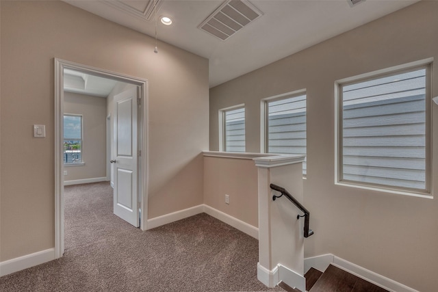interior space featuring visible vents, attic access, baseboards, and carpet floors
