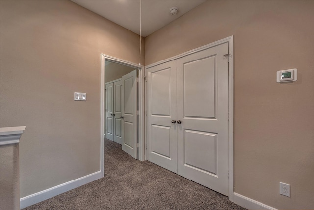 hallway with baseboards and carpet