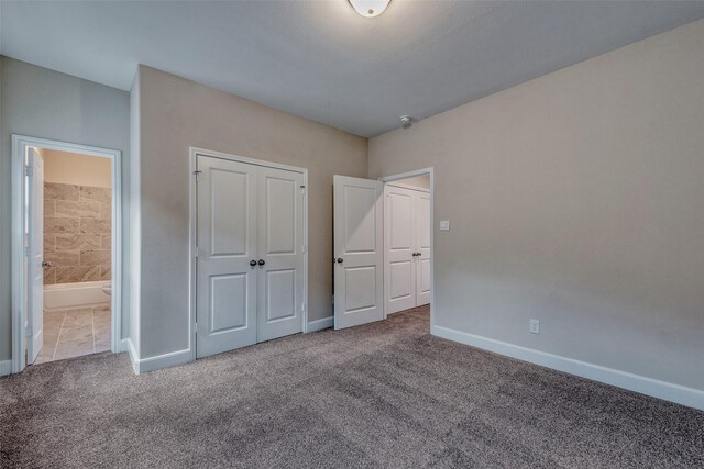 unfurnished bedroom with carpet floors, baseboards, connected bathroom, and a closet