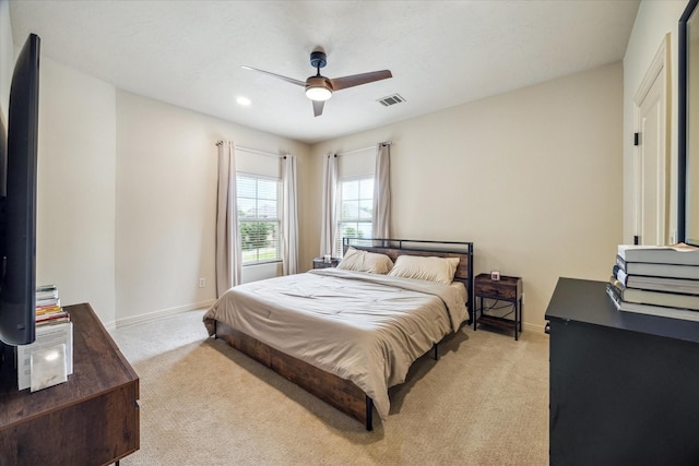 bedroom featuring visible vents, baseboards, and light carpet