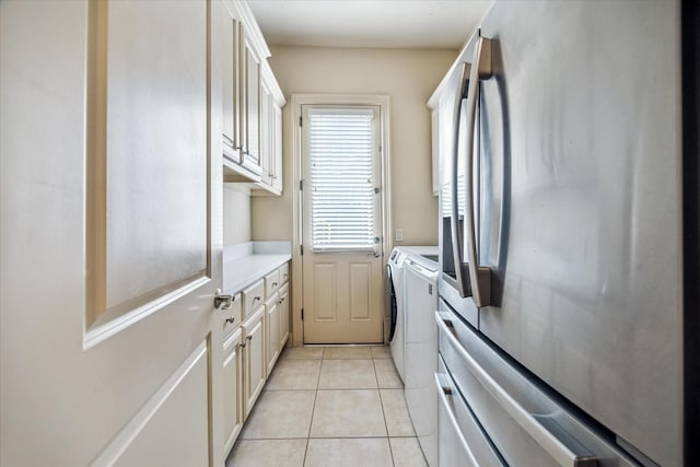 laundry area with cabinet space, washing machine and dryer, and light tile patterned flooring