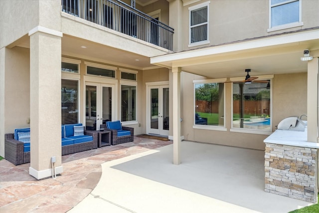 view of patio / terrace featuring french doors, ceiling fan, an outdoor kitchen, and a balcony