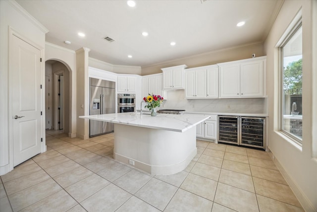 kitchen featuring arched walkways, stainless steel double oven, light tile patterned floors, and built in fridge
