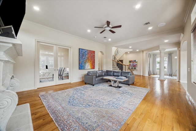 living area with crown molding, visible vents, stairs, ceiling fan, and ornate columns