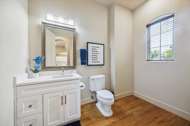 bathroom featuring vanity, baseboards, toilet, and wood finished floors