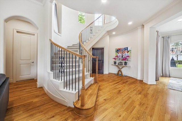 stairway featuring recessed lighting, baseboards, ornamental molding, and wood finished floors