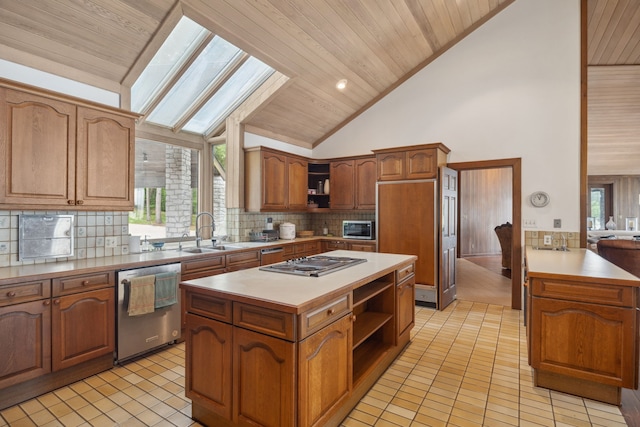 kitchen with appliances with stainless steel finishes, tasteful backsplash, open shelves, a center island, and a sink