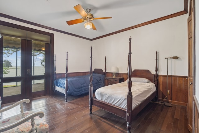 bedroom featuring french doors, wainscoting, wooden walls, and wood finished floors
