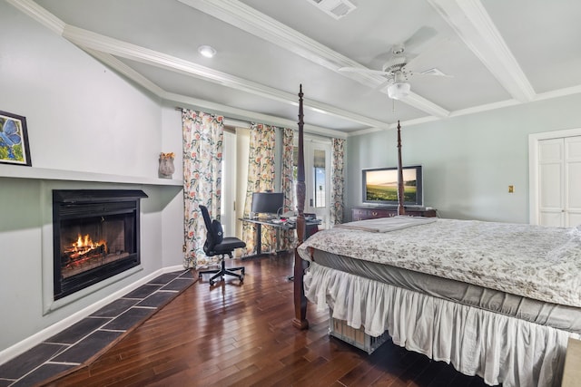 bedroom featuring visible vents, ornamental molding, wood finished floors, baseboards, and a lit fireplace