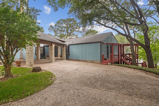 view of property exterior featuring roof with shingles and concrete driveway
