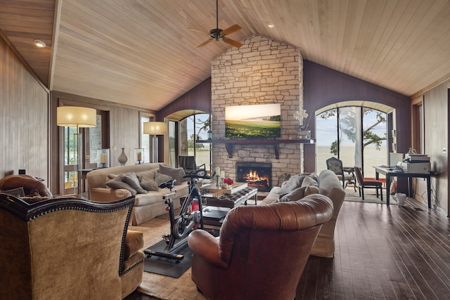 living area featuring wooden ceiling, ceiling fan, vaulted ceiling, and wood walls