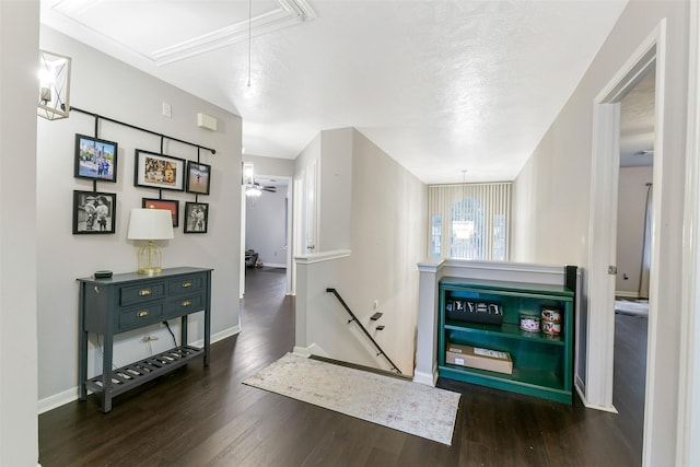 hallway featuring baseboards, an upstairs landing, wood finished floors, and attic access