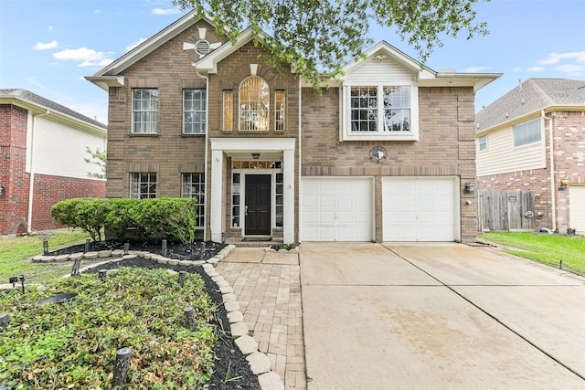 traditional-style house featuring fence, brick siding, a garage, concrete driveway, and a balcony