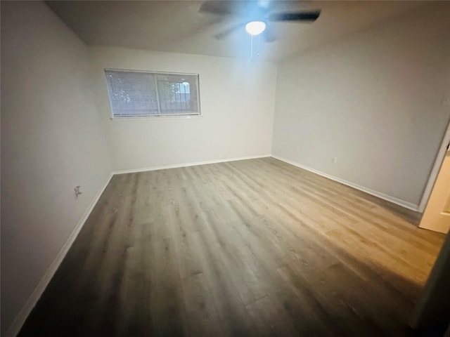 spare room featuring baseboards, ceiling fan, and wood finished floors
