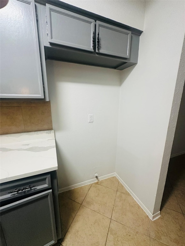 room details featuring baseboards, backsplash, and gray cabinetry