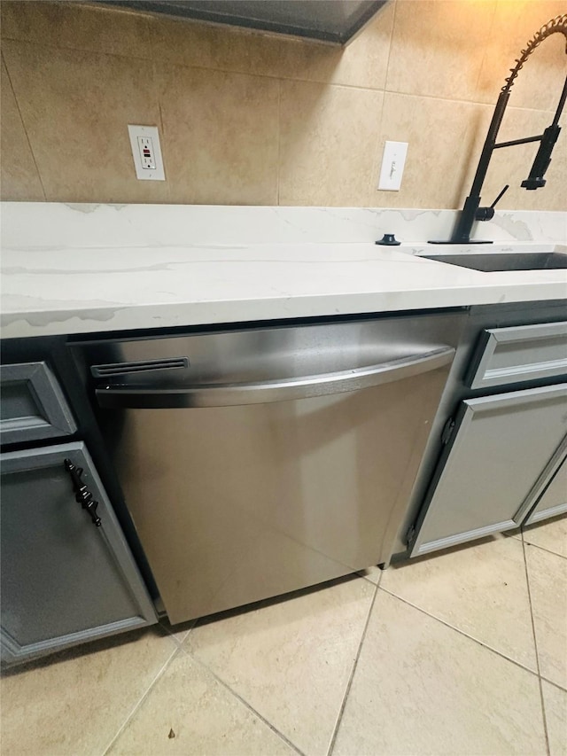 details featuring stainless steel dishwasher, a sink, and light countertops