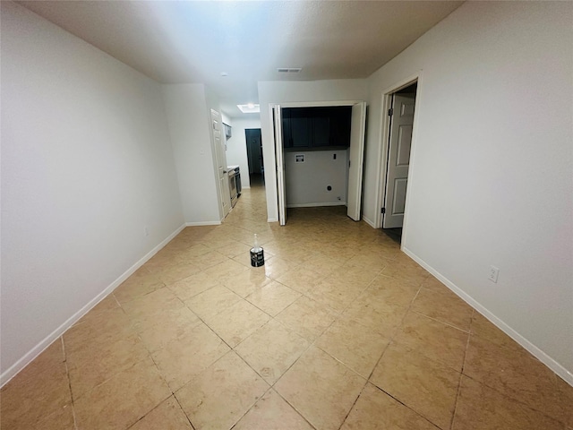 spare room with baseboards, visible vents, and light tile patterned floors