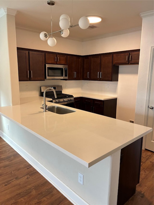 4327 Robertson St, Houston, TX 77009 - kitchen with dark brown cabinetry, a sink, a peninsula, ornamental molding, and stainless steel appliances