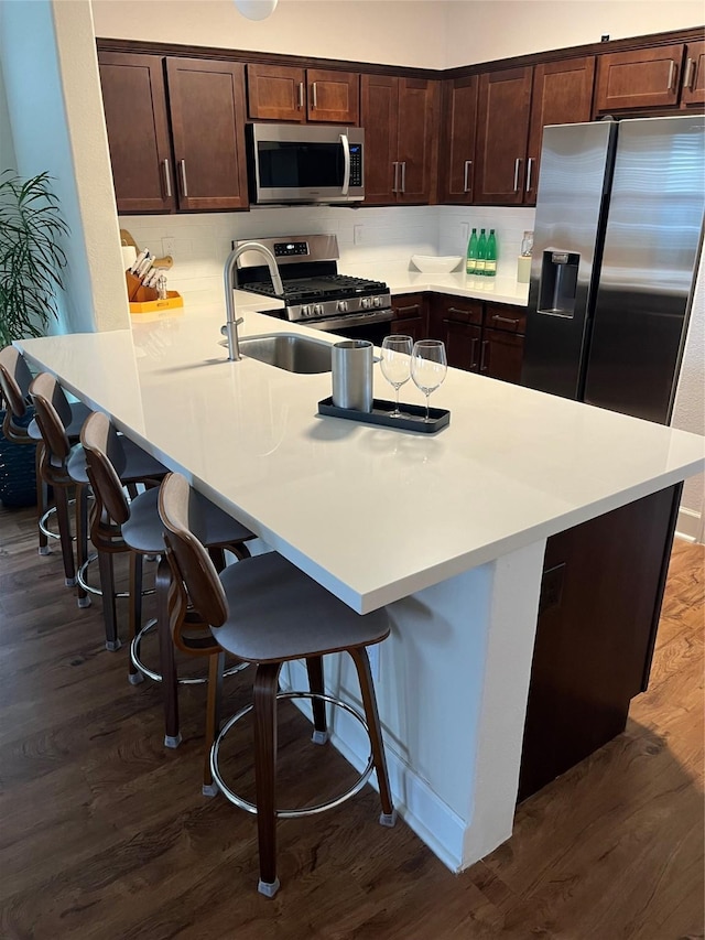 4327 Robertson St, Houston, TX 77009 - kitchen with light countertops, stainless steel appliances, dark brown cabinetry, and a kitchen bar