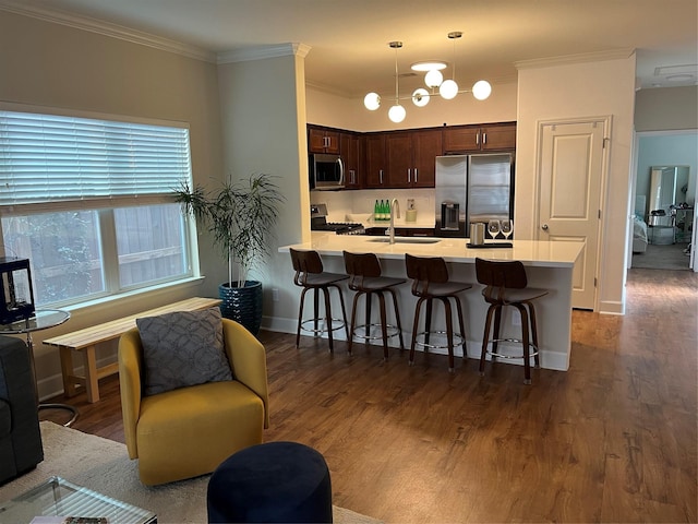 4327 Robertson St, Houston, TX 77009 - kitchen featuring a peninsula, appliances with stainless steel finishes, dark brown cabinetry, and a kitchen bar