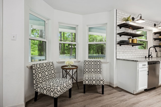living area featuring baseboards and light wood-style flooring