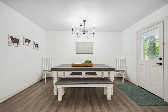 dining room featuring baseboards, wood finished floors, and a chandelier