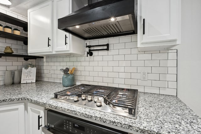 kitchen with exhaust hood, backsplash, stainless steel gas cooktop, open shelves, and oven