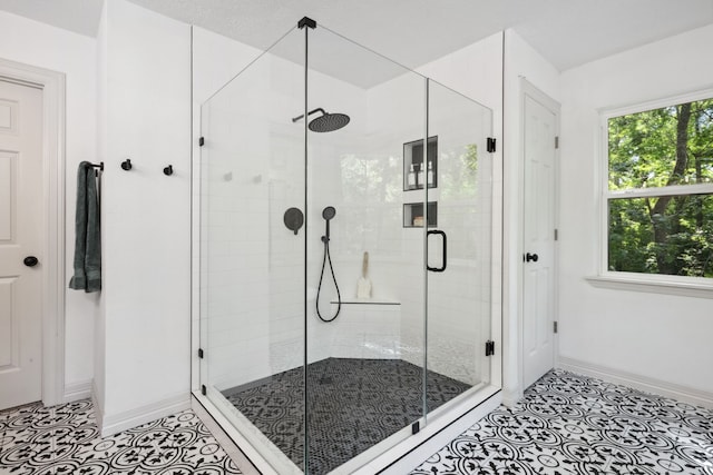 bathroom with baseboards, tile patterned floors, and a stall shower