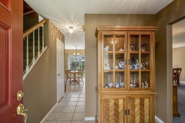 11203 Rocky Mill Dr, Cypress, TX 77429 - interior space featuring baseboards, stairs, light tile patterned flooring, and a notable chandelier