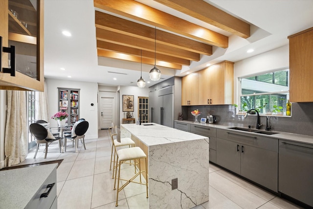 kitchen with paneled dishwasher, a sink, backsplash, and built in fridge