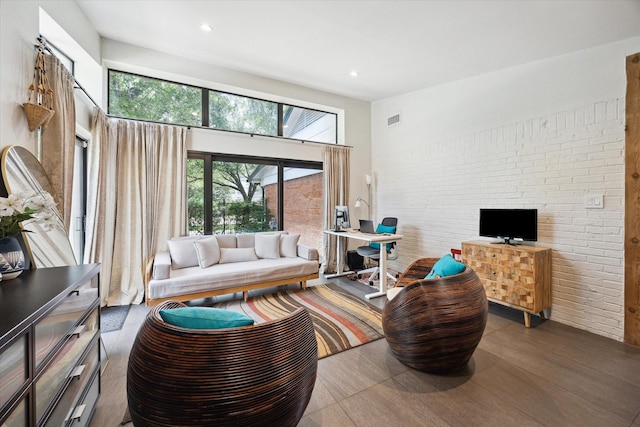 living room featuring visible vents, recessed lighting, wood finished floors, and brick wall