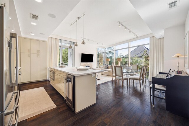 2207 Bancroft St Unit 301, Houston, TX 77027 - kitchen featuring rail lighting, dark wood finished floors, hanging light fixtures, open floor plan, and expansive windows