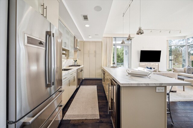 2207 Bancroft St Unit 301, Houston, TX 77027 - kitchen with appliances with stainless steel finishes, a center island, a breakfast bar area, dark wood-type flooring, and open floor plan