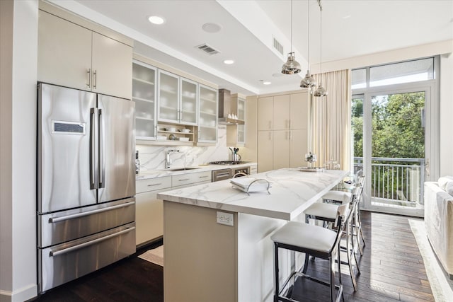 2207 Bancroft St Unit 301, Houston, TX 77027 - kitchen with stainless steel fridge, wall chimney range hood, dark wood-style floors, a kitchen island, and a sink