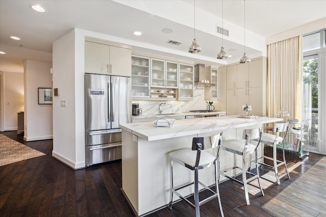 2207 Bancroft St Unit 301, Houston, TX 77027 - kitchen featuring stainless steel fridge, wall chimney range hood, dark wood-type flooring, a kitchen island, and recessed lighting