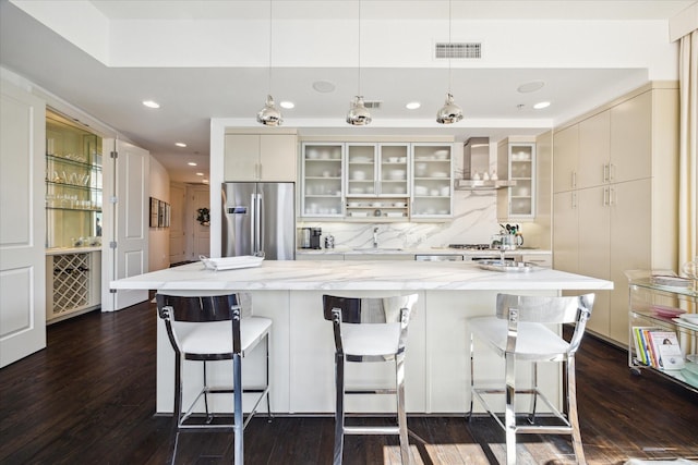 2207 Bancroft St Unit 301, Houston, TX 77027 - kitchen featuring stainless steel fridge with ice dispenser, wall chimney exhaust hood, a sink, a center island, and dark wood finished floors