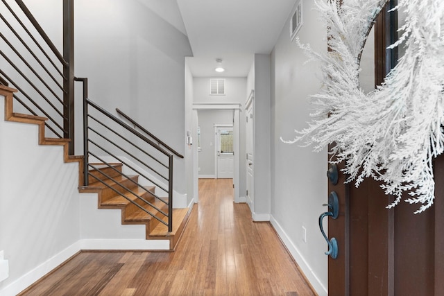 entryway with baseboards, wood finished floors, and visible vents