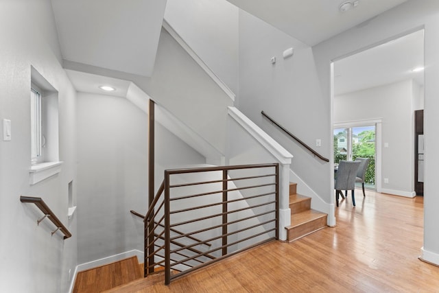 staircase with baseboards, recessed lighting, and wood finished floors
